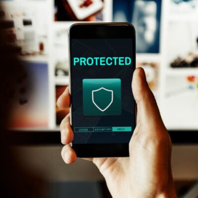 person holding a mobile phone displaying a shield and the word protected